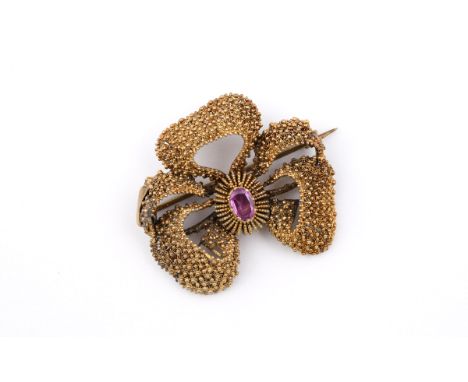 A GOLD BOW BROOCH the stylised bow design with granular decoration and centred with an oval-shaped ruby, 4cm wide