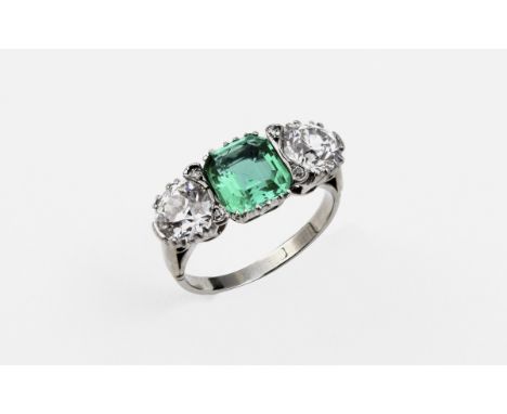 AN EDWARDIAN EMERALD AND DIAMOND THREE STONE RING the octagonal-cut emerald is set with two circular old-cut diamonds. Size J