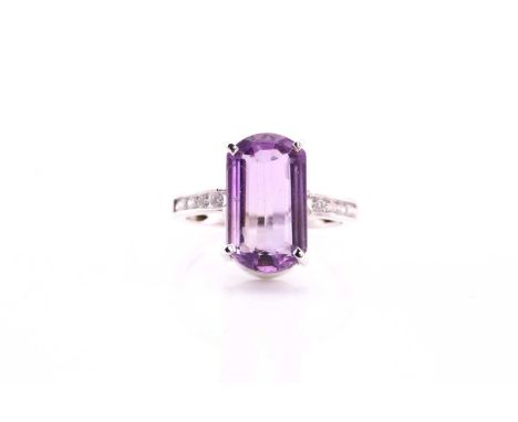 An amethyst and diamond dress ring, consisting of a central fancy cut amethyst measuring 16x10mm claw set into a white metal 