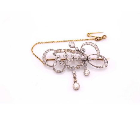 An Edwardian diamond set scroll brooch, consisting of old cut diamonds with an estimated weight of 1.40ct set into white meta