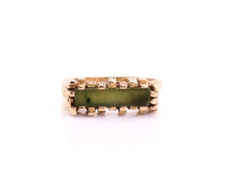 A 9ct yellow gold jade ring, with a bark effect castellated shoulders, to a polished shank, assay marks for 1973, AJ Ld maker