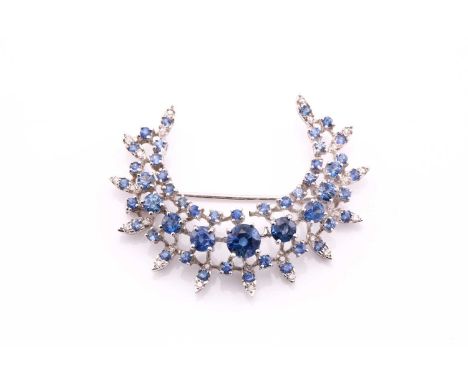 A sapphire and diamond crescent shape brooch, the round sapphires graduate from 1.7 – 6.0mm in diameter, all claw set to a wh