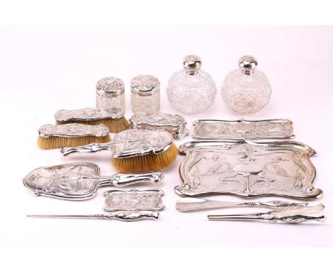 An Art Nouveau silver backed dressing table set, each piece chased with stylised flowering foliage with kingfishers, comprisi