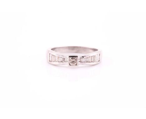 A diamond ring, the central round brilliant cut diamond, and baguette, and tapering baguette cut shoulders in 9 carat white g