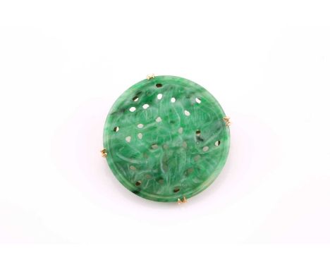 A circular carved jade brooch, mid 20th century, doubled claw set to a yellow precious metal mount, pin fittng, 2.7cms diamet