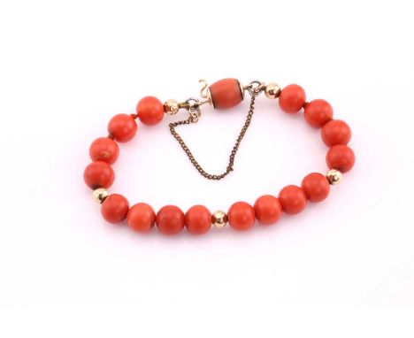 Red coral bead bracelet, averaging 8.5mm diameter, with yellow precious metal rondelle links, with safety chain, 17.5cms long