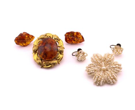 A lot consisting of two brooches and two sets of earrings, the first item is an oval cabochon Amber set brooch on yellow meta