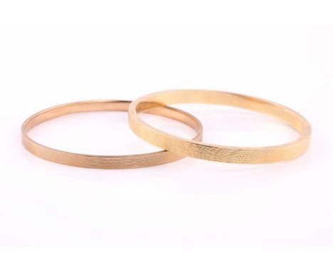 Two gold bangles comprising of a 15ct hollow bangle the interior diameter approximately 6.5cm and a 9ct rose gold bangle with