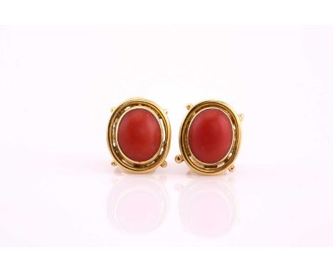 A pair of coral cabochon earrings, within yellow precious metal collet settings and peg and clip fittings, stamped ‘750’, 1.5