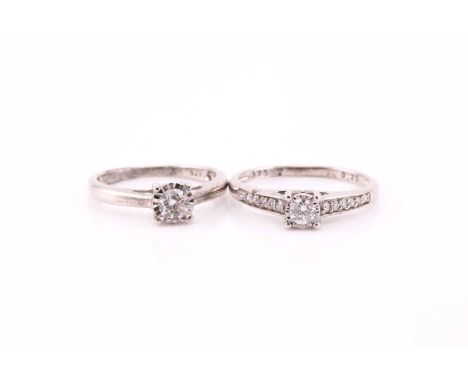 A diamond single stone ring; the round brilliant cut diamond in illusion mount, with twelve stone diamond shoulders, in 9 car
