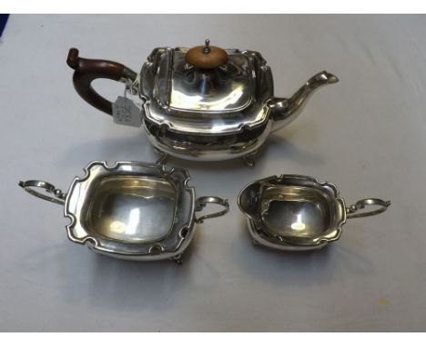 A George V Silver Three Piece Tea Service, comprising Teapot, Sugar Basin and Milk Jug, all with looped handles, raised on fo
