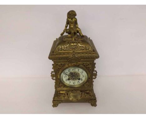 A late 19th Century Cast Brass Mantel Clock, the case with cushion moulded pediment surmounted by a putto to cast and pierced