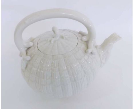 A Belleek Shell Moulded Teapot with seaweed handle, decorated typically in plain blanc de chine (spout chips), 8" long 
