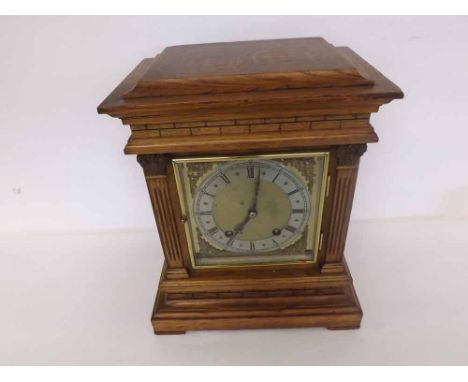 An early 20th Century Oak Cased Mantel Clock, the plinth-shaped case with overhanging cornice and plain frieze to architectur