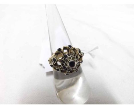 Unusual high grade yellow metal pierced and domed fronted Ring, set throughout with small dark blue Sapphires, stamped "18K" 