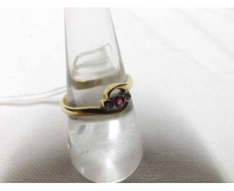 Unmarked yellow metal ring of cross over design, centre small Ruby flanked to each side by a small rose cut Diamond   55-65