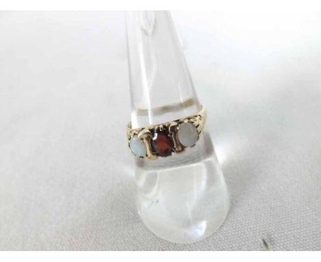 A hallmarked 9ct Gold Ring featuring a centre Garnet, flanked to each side by a small Oval Opal, carved setting