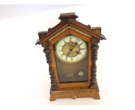 An early 20th Century Walnut and Plaster Mounted Mantel Timepiece, the arched case with glazed door and half ring-turned colu