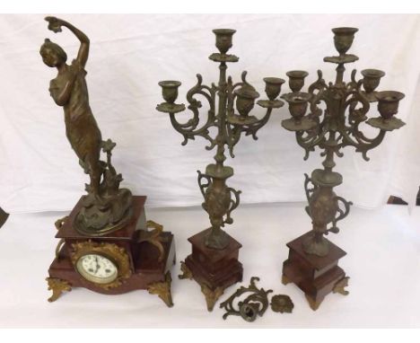 An early 20th Century variegated rouge marble and patinated spelter mounted clock garniture, the plinth-shaped base surmounte