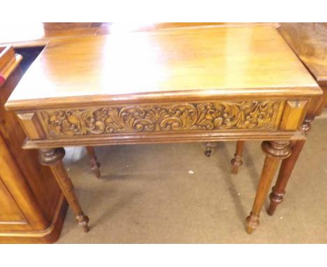 An Oak Fold Top Card Table, moulded edge over a carved frieze and raised on ring-turned and reeded tapering supports with peg