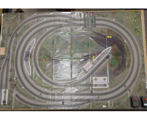 'OO' gauge table top model railway layout on wooden board, the concentric loops of track on a printed background, various kit