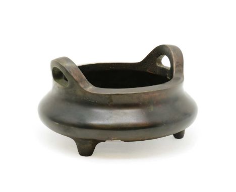 A Chinese bronze incense burner,20th century, of compressed globular form on three stud feet, with two handles, a four-charac