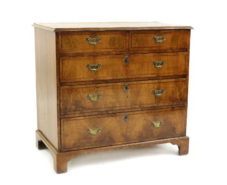 A walnut chest of drawers,second quarter 18th century and later, with a cross-grain moulded top, over two short and three lon