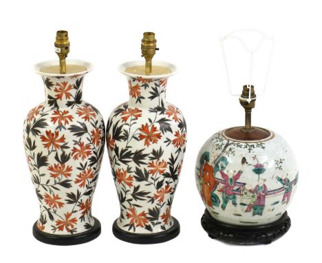 A famille rose porcelain lamp,20th century, of globular form, decorated with figures beneath a tree, on a pierced wood stand,