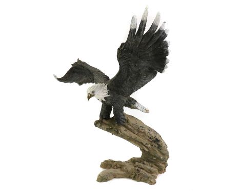 A large cold painted bronze eagle,with outstretched wings, perched on a branch,107cm wide103cm highCondition ReportIn need of