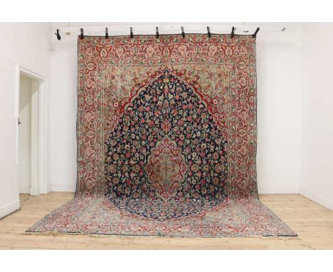 A Kirman carpet,decorated with dense foliate motifs, with a navy central field, and red borders,410 x 283cmCondition ReportSo