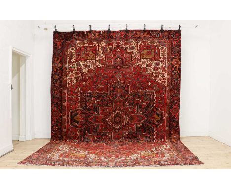 A Heriz carpet,of recent manufacture, with a large central floral medallion, to a red field, and navy borders,287 x 391cmCond