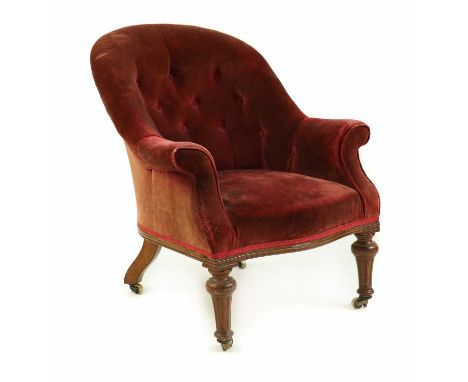 A Victorian armchair,by Holland &amp; Sons, the button back above stuff over seat in red on castor turned supports, the back 