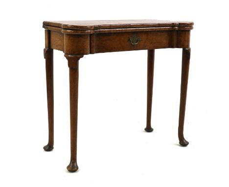 A crossbanded walnut fold-over card table,the shaped top opening on double gate supports to reveal counter wells and candle s