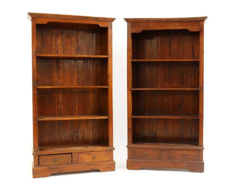 A pair of hardwood open front bookcases,20th century, each with two short lower drawers, raised on a plinth,97cm wide33.5cm d