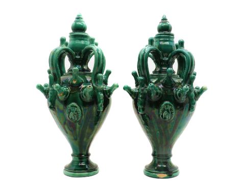 A pair of green glazed stoneware urns,early 20th century, possibly Sardinian marriage urns, each of baluster form with four h