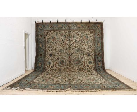 A large Persian carpet,20th century, decorated with foliate motifs to a pale field enclosed by pale blue borders,510 x 351cmC