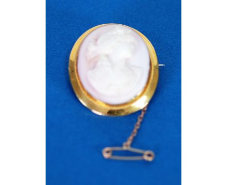 9ct GOLD FRAMED OVAL SHELL CAMEO BROOCH carved with a female head, 1 5/8" high and the safety chain, 12 gms gross