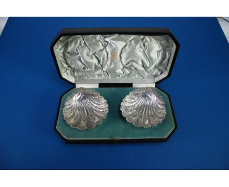 PAIR OF LATE VICTORIAN SILVER SCOLLAP SHELL SHAPED DISHES, chased and repousse and with radiating flutes, decorated with foli