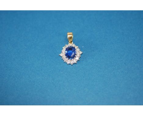 AN APPARENTLY TESTED 18ct YELLOW AND WHITE GOLD PENDANT ADAPTED FROM A RING, set with a cornflower blue sapphire within a sur