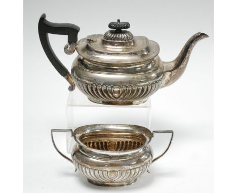 AN EARLY TWENTIETH CENTURY SILVER DEMI GADROONED ROUNDED OBLONG TEA POT, with blackwood handle and finial, with matching SUGA