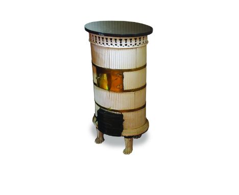 A late 19th/early 20th century Northern European white glazed ceramic and brass mounted oval stove with moulded reeded body a
