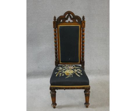 A late Victorian walnut Gothic carved prie dieu style side chair in floral tapestry upholstery. H.103cm 