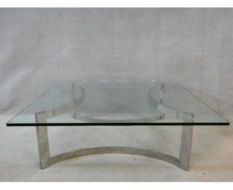 A vintage low table in the style of Gavina, the heavy plate glass top resting on a shaped chrome base. H.38 W.119 D.119cm 