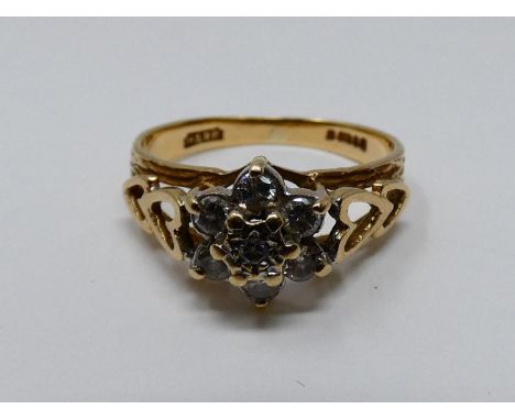 A vintage diamond and 9ct yellow gold floral cluster ring, set with seven round brilliant cut diamonds, heart motifs to the s