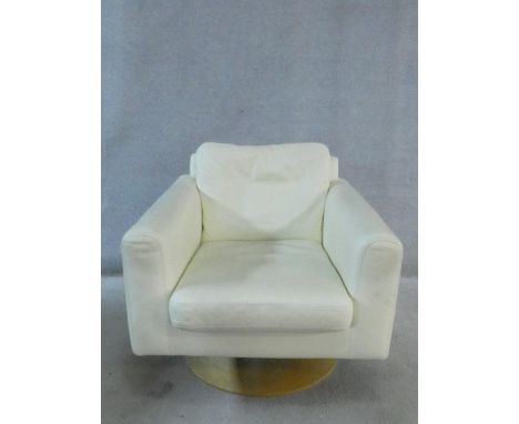 A vintage style revolving armchair in cream leather upholstery on circular laminated base. H.68 W.74 D.77cm 