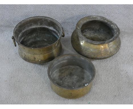 Three vintage hammered brass Indian Handis (cooking pots). One with hinged circular handles and rounded feet and a angular ri