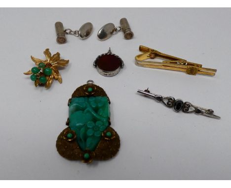 A collection of jewellery. Including an Art Deco jade glass and brass fruit design pendant, a pair of silver cufflinks in the