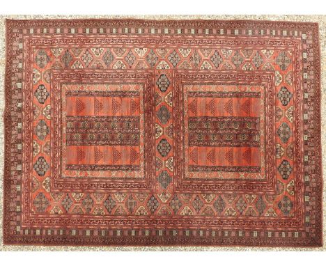 A Belgian Louis de Poortere Persian style carpet, decorated with geometric designs on a red ground, 400 x 300cm