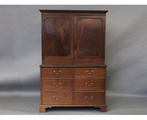 A George III mahogany linen press, with a pair of panel doors enclosing trays, above six short drawers, on bracket feet, 127c