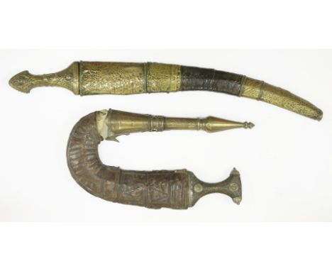 A janbiya, with a metal inset handle and ornate brass and leather sheath, andanother, with an ornate brass handle and brass-m